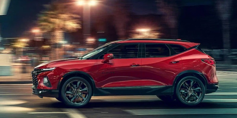 Red 2021 Chevrolet Blazer driving down city roads.