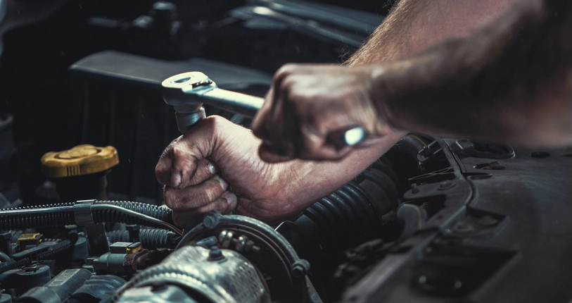 Man repairing car engine. Close up shot of the mans hands.