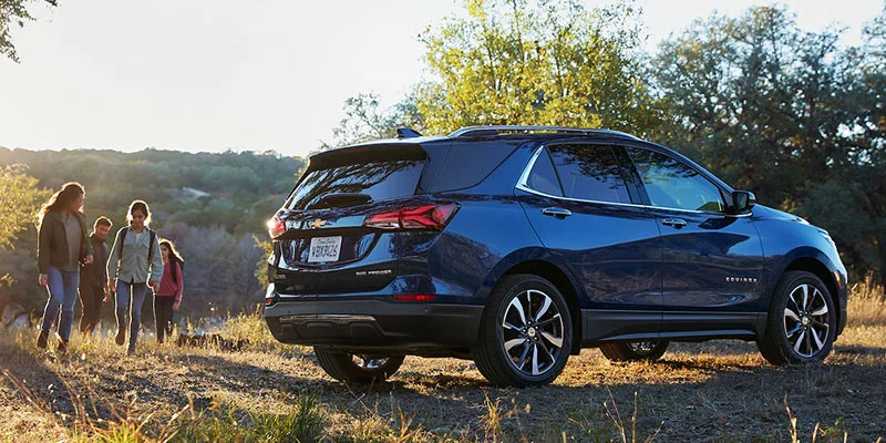 Family at a hiking spot in their new blue 2022 Chevrolet Equinox
