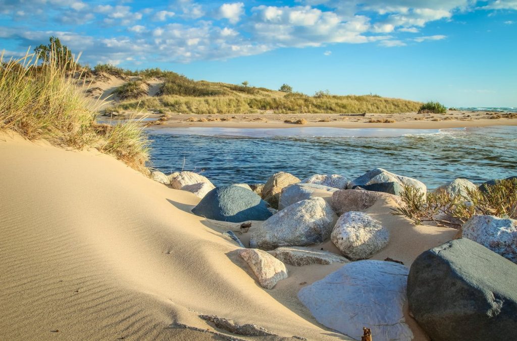 A beautiful beach scene with smooth stone lining the shoreline at a Michigan state park.