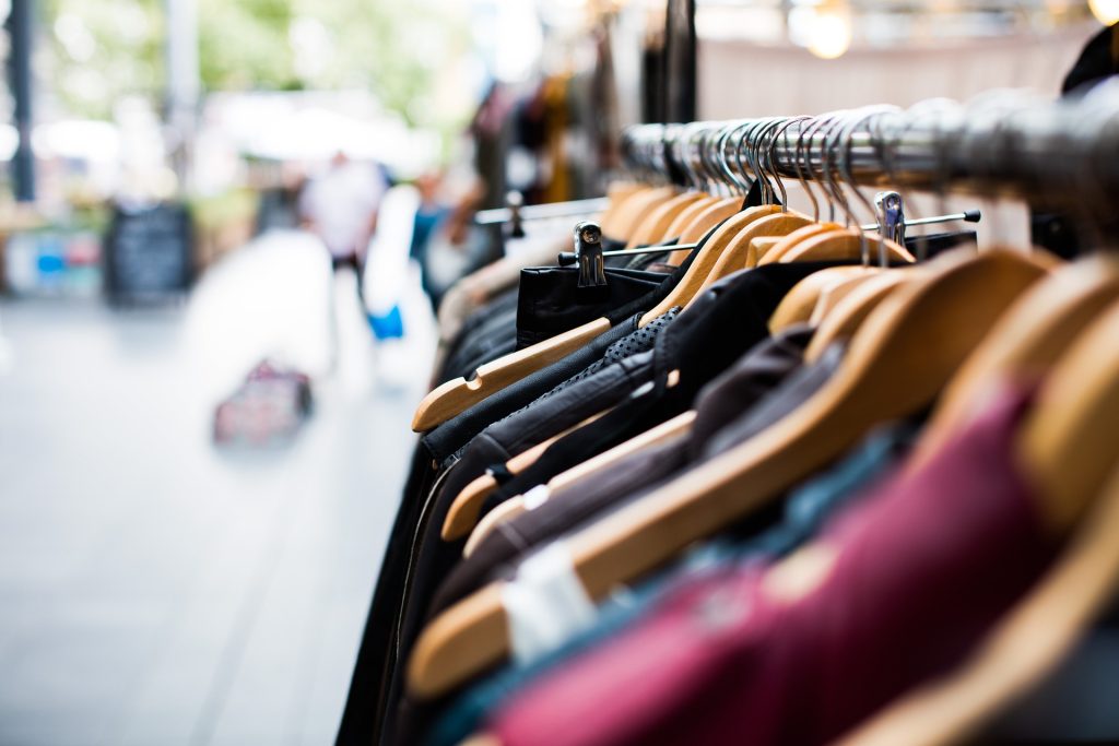 close up shop of a clothes rack where you can see the top left of all the clothes going down the clothes rack.