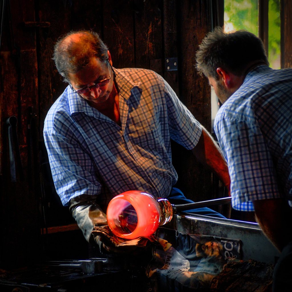 2 men glass blowing some sort of large bowl
